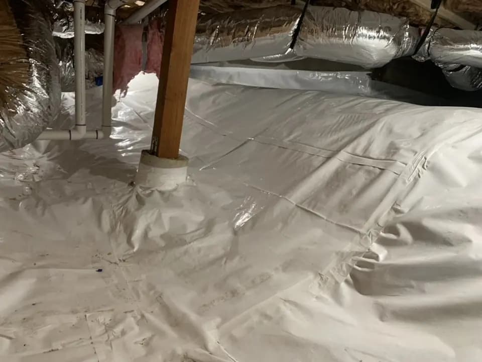 Crawl space floor covered with a white vapor barrier